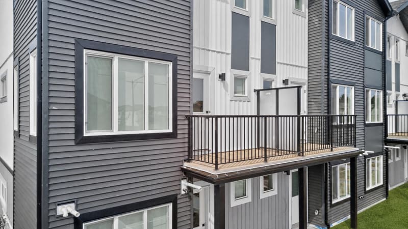 Private balcony with metal railing and wood-look decking